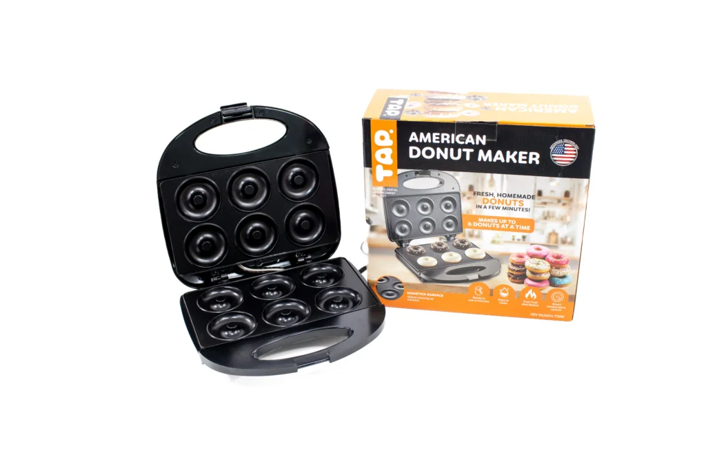 american donut maker next to its packaging box on a white background